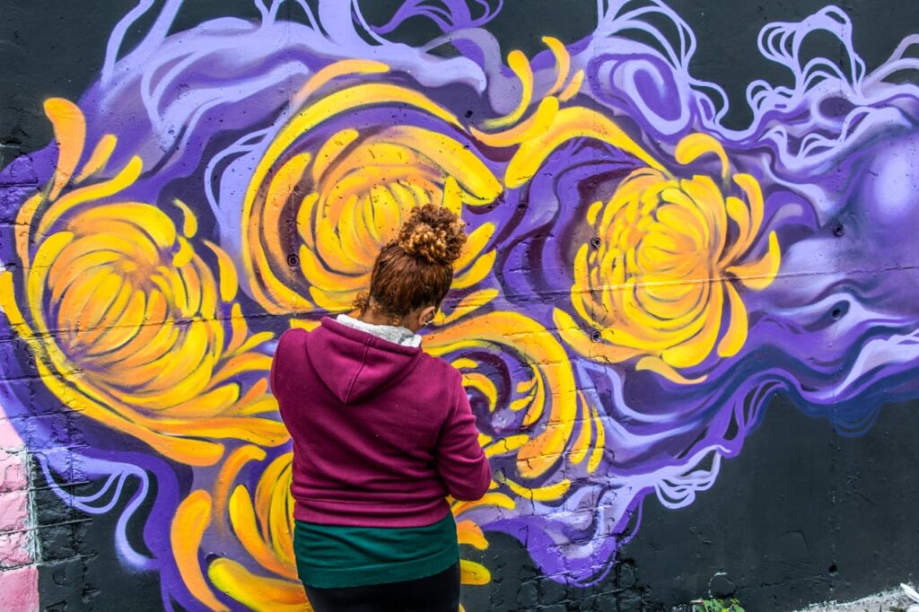 Kelly trabalhando em seu mural na West Side Gallery 2, que também contou com a ajuda da artista Vitcha Matos. Para Kelly, ainda existe machismo com mulheres grafiteiras